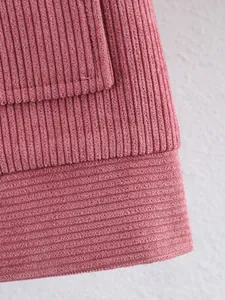 Macro-opname van de roze corduroy stof en de stiksels op een casual damesjasje.