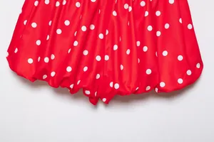 Primer plano de tela roja con lunares blancos y detalle de dobladillo abullonado