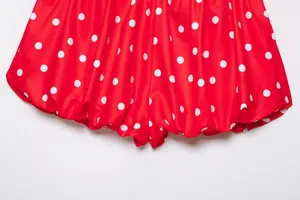 Primer plano del dobladillo plisado en los pantalones cortos de lunares rojos y blancos.