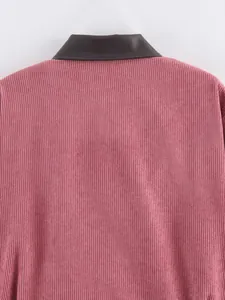Detailopname van roze corduroy textuur en contrasterende donkerbruine imitatieleren kraag