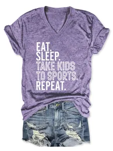 Vue détaillée d'un t-shirt violet à col en V avec le texte Eat Sleep Take Kids To Sports.