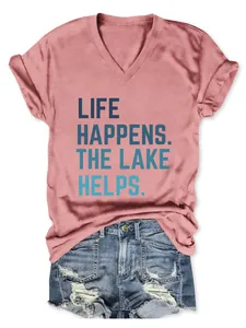 Detail van roze T-shirt met V-hals en 'Life Happens The Lake Helps' tekstuele print.