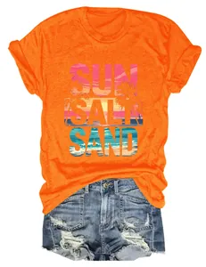 Primo piano di t-shirt arancione con stampa 'SUN SALT SAND' e paesaggio marino