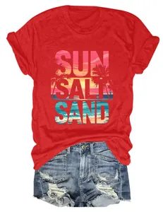 T-shirt estiva rossa da donna con una vivace stampa tropicale Sun Salt Sand sulla spiaggia.