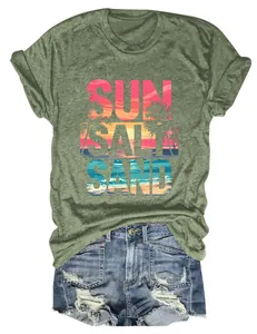 Dettaglio della stampa Sun Salt Sand su t-shirt verde melange con shorts di denim.