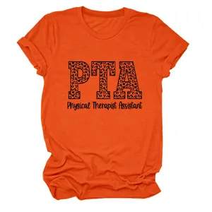 Detalle del texto PTA con estampado de leopardo en una camiseta naranja de asistente.