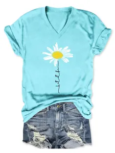 Détail d'un t-shirt bleu clair à col en V avec imprimé marguerite et short en jean