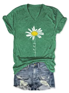 Détail de l'imprimé marguerite et du texte let it be sur un t-shirt vert col en V pour femmes
