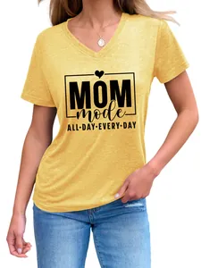 Vista de detalle de una camiseta amarilla de cuello en V con diseño 'Mom Mode' en una modelo