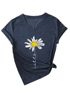 Gros plan sur l'imprimé marguerite et le texte « let it be » sur un t-shirt bleu foncé.