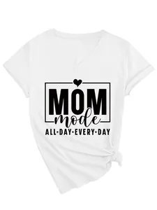Detalle del estampado gráfico 'MOM mode ALL DAY EVERY DAY' en una camiseta blanca con cuello V