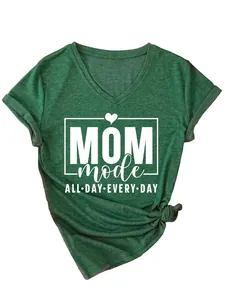 Detalle de camiseta verde jaspeada cuello en V con estampado blanco de "MOM mode"