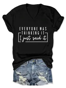 Gros plan du slogan imprimé sur un t-shirt noir à col en V pour femme en coton.