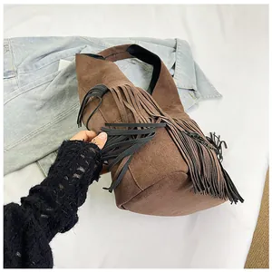 Close-up of retro brown suede tote bag with stylish black tassel details
