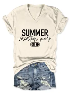 Close-up of beige V-neck tee with 'Summer Vacation Mode' print and denim shorts.