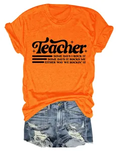 Dettaglio della maglietta arancione slogan Teacher e shorts di jeans blu strappati
