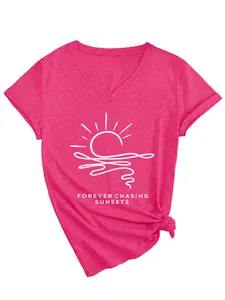 Close-up detail of the forever chasing sunsets white print on a pink V-neck T-shirt.