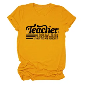 Vista dettagliata della t-shirt gialla con stampa grafica 'Teacher' e morbido cotone
