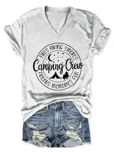 Casual women's V-neck white tee featuring Camping Crew hiking and campfire graphic design