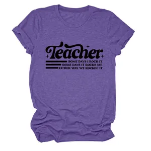 Dettaglio della stampa grafica 'Teacher' su una t-shirt viola a maniche corte