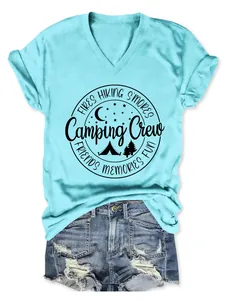 Detail of a light blue V-neck t-shirt featuring a black circular Camping Crew graphic