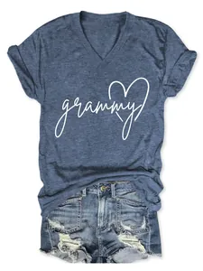Detalle de la inscripción grammy y el corazón blanco en camiseta azul con cuello en V.