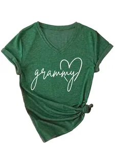 Detalle de la camiseta verde con cuello en V e impresión de corazón 'grammy' blanca delante.