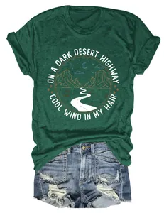 Détail du t-shirt vert avec motif de désert et citation sur fond blanc neutre