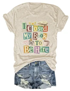 Close-up of "I Closed My Book To Be Here" graphic print on soft beige women's T-shirt