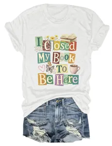 Close-up of white women's t-shirt featuring colorful 'I Closed My Book To Be Here' graphic