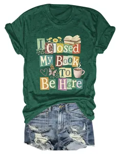 Detailed view of dark green T-shirt with 'I Closed My Book To Be Here' graphic print