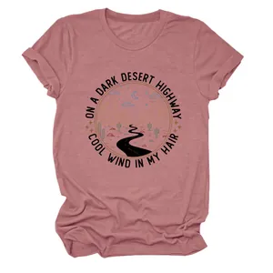 Gros plan d'un t-shirt rose poudré avec graphique de route du désert et paroles