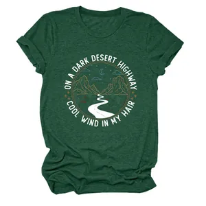 Détail d'un t-shirt femme vert foncé avec graphique de route du désert et texte.