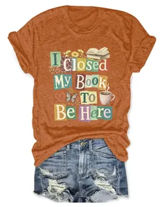 Graphic detail of 'I Closed My Book To Be Here' slogan on orange women's T-shirt