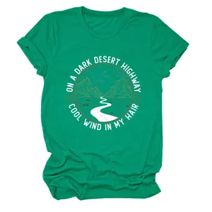 Gros plan détaillé du t-shirt vert émeraude pour femme avec un imprimé graphique de désert