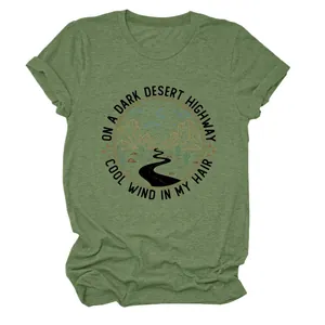 Gros plan d'un t-shirt vert avec un imprimé graphique de route de désert sombre