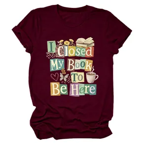 Close-up of the 'I Closed My Book To Be Here' colorful graphic print on a burgundy T-shirt