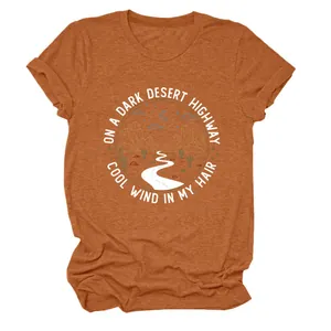 T-shirt femme orange rouille avec impression graphique 'On a Dark Desert Highway'.