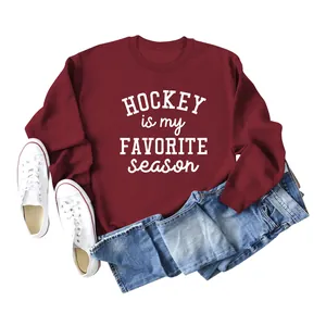 Close-up of 'Hockey is my favorite season' print on burgundy sweatshirt detail.
