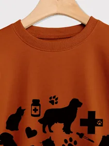 Close-up of ribbed neckline and pet medical theme print on orange sweatshirt