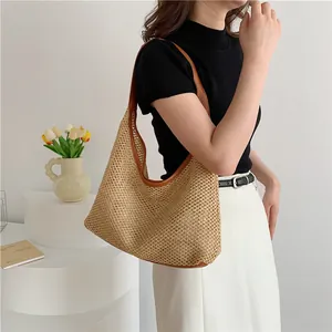 Fashionable handwoven large capacity hobo bag with brown leather trim carried by a model