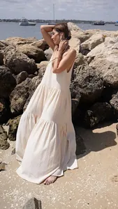 Close-up detail of a loose cream-colored tiered maxi beach dress with pleated texture
