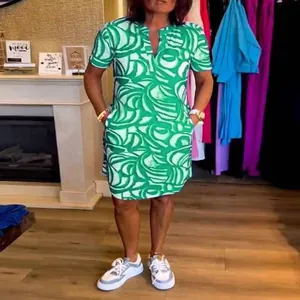 Detail view of a women's summer short-sleeved V-neck dress with green abstract print