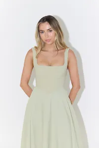 Front detail of an elegant sage green square neck slim fit midi dress worn by a model.