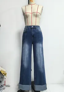 Vue détaillée d'un jean taille haute à jambes larges avec revers et couture centrale.