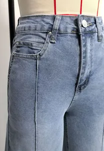 Gros plan d'un jean bleu délavé à taille haute avec couture centrale détaillée