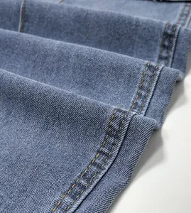 Gros plan de la double couture jaune sur la texture d'un jean en denim bleu clair