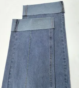 Détail du revers large et de la couture centrale décorative sur un jean en denim rétro