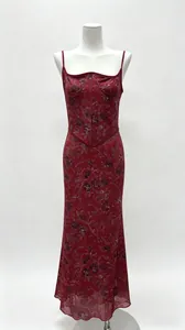 Dettaglio dell'elegante abito da sera bordeaux con paillettes, motivi floreali e corsetto