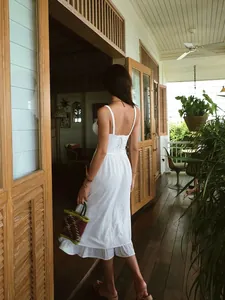 Rear view of white French vacation style midi dress featuring a lace-up back detail